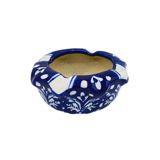 Blue ceramic ashtray with white floral patterns on a white background