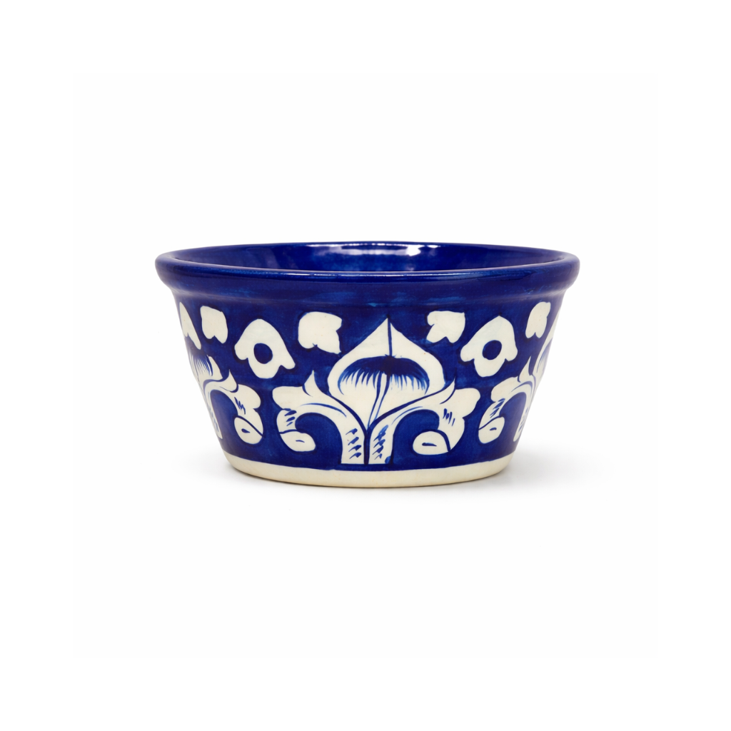 Blue ceramic ketchup bowl with white floral patterns on a white background