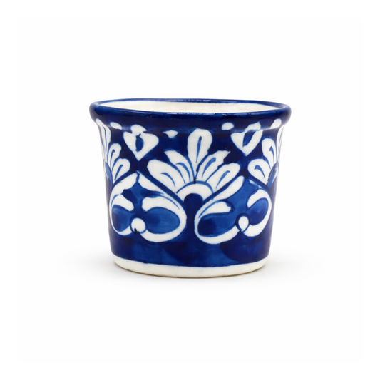 Blue ceramic cup with white floral patterns on a white background