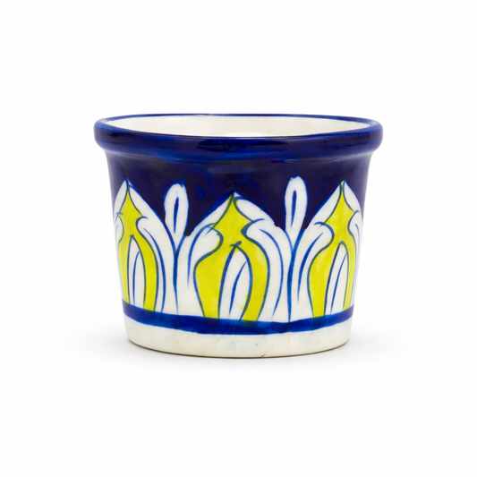 Ceramic cup with blue and yellow floral pattern on a white background