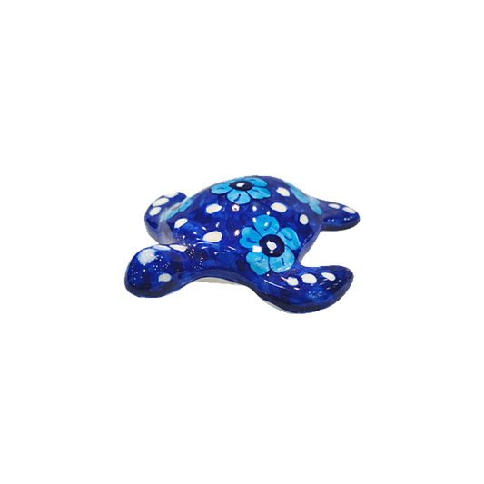 Blue ceramic turtle with white polka dots and floral patterns on a white background