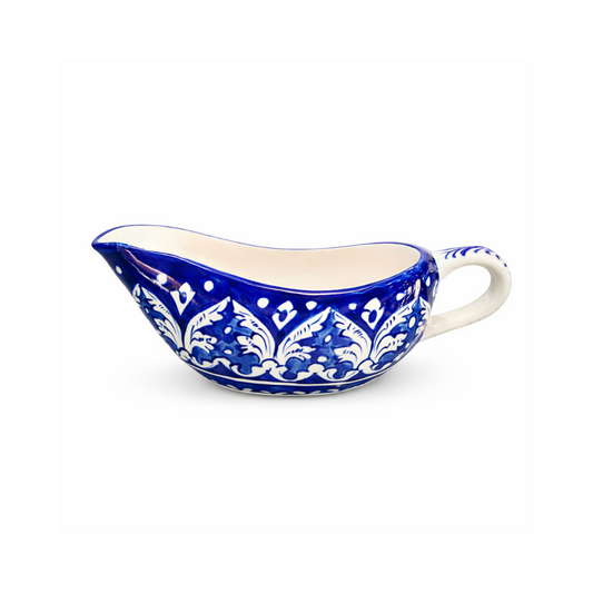 Ceramic gravy boat with blue and white pattern on a white background